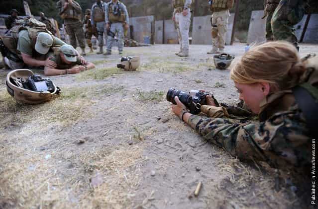 Lance Cpl. Erica B. DiSalvo, assigned to Headquarters Squadron, Consolidated Public Affairs Office, Marine Corps Air Station Miramar, documents Tactical Firearms Training Team instructors as they demonstrate how to search a detainee during a training evolution for the Fleet Combat Camera Group Pacific Summer Quick Shot 2011 field training exercise