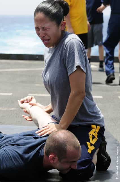 Culinary Specialist 2nd Class Jaqueline Rodriguez subdues a simulated suspect after being sprayed with oleoresin capsicum (OC) spray during security training aboard the amphibious dock landing ship USS Comstock (LSD 45)