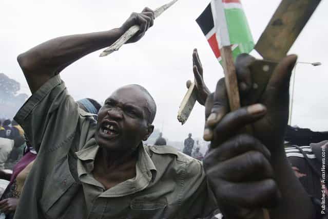A supporter of defeated Kenyan presidential election candidate Raila Odinga waves a stick during protests in Kibera, an opposition stronghold