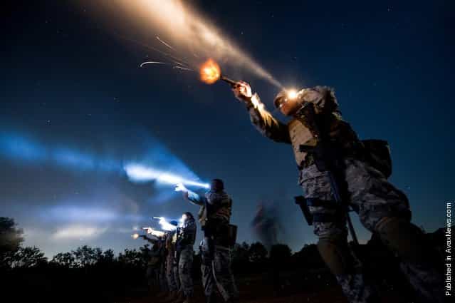 Tech. Sgt. Milo Hinson, 3rd Combat Camera Squadron, uses a flashlight while shooting a Berretta 9mm during the night-fire portion of Advance Weapons, Tactics and Techniques training in San Antonio. During night-fire training, airmen learn how to tactically illuminate targets with flashlights and practice using night vision goggles