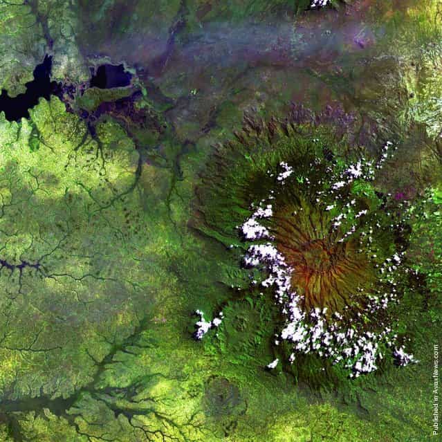 Clouds encircle the lofty rim of Africa’s Mount Elgon, a huge, long-extinct volcano on the border between Uganda and Kenya