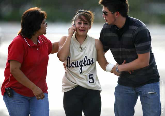 Douglas High School softball player Stephanie Ybarra is consoled after her father and Douglas assistant coach David Ybarra was taken to the hospital by ambulance after suffering a heart attack in the dugout before the game