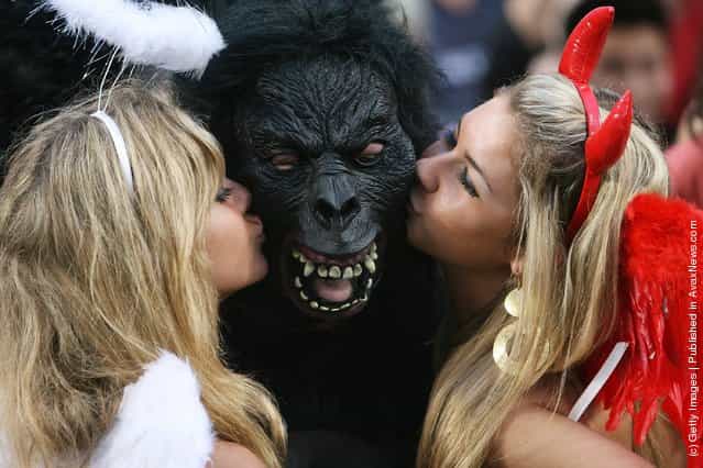 Rugby fans kiss a fellow spectator wearing a gorilla mask during the Hong Kong Rugby Sevens 2008 on March 28, 2008 in Hong Kong, China