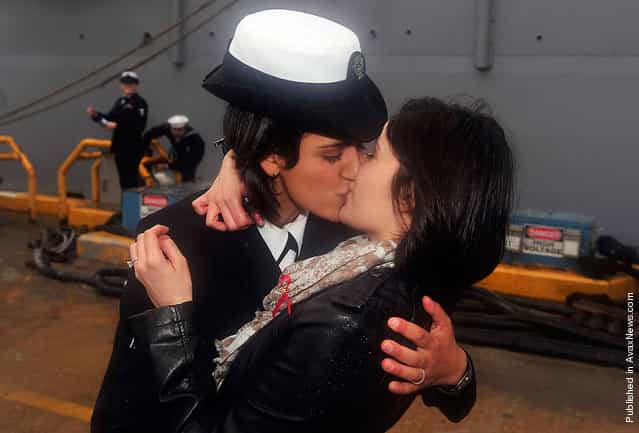 Petty Officer 2nd Class Marissa Gaeta (left), assigned to the amphibious dock landing ship USS Oak Hill, kisses her partner Petty Officer 3rd Class Citlalic Snell, following the ships return to homeport after a three-month deployment in the Caribbean, in Virginia Beach, Virginia, on December 21, 2011. History was made on a Virginia Beach pier on Wednesday when the two women sailors, one just home from 80 days at sea, became what was believed to be the first same-sex couple to share the Navys traditional first kiss