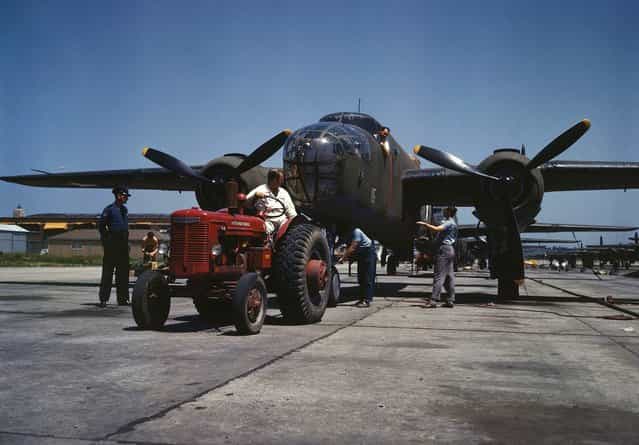 B-25 bomber planes at the North American Aviation, Inc., being hauled along an outdoor assembly line with an International tractor, in Kansas City, Kansas, in October, 1942