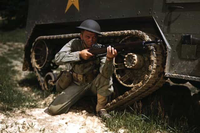 A young soldier of the armored forces holds and sights his Garand rifle like an old timer, at Fort Knox, Kentucky. He likes the piece for its fine firing qualities and its rugged, dependable mechanism. Photographed in June of 1942