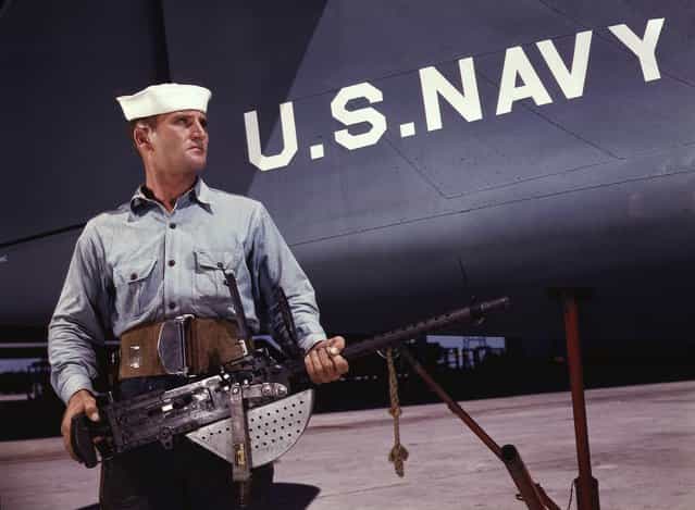 A american non-com at the side machine gun of a huge YB-17 bomber is a man who knows his business and works hard at it. Photographed in May, 1942