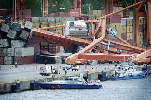People look on after the gantry of the Baltic Container Terminal fell down onto shipping containers at the waterfront in Gdynia, Poland. Three people were injured in the accident