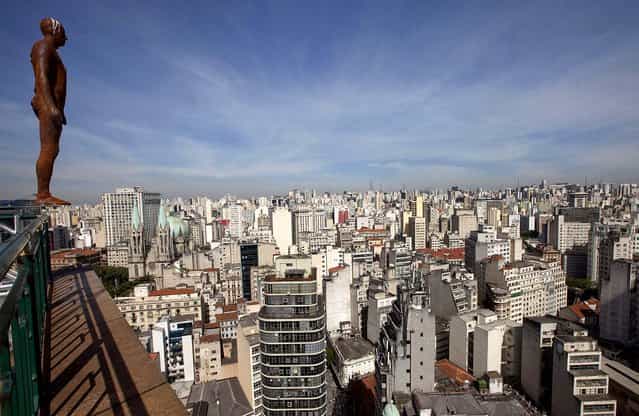 A sculpture by British artist Antony Gormley is displayed on the edge of a building in downtown Sao Paulo on May 11, 2012
