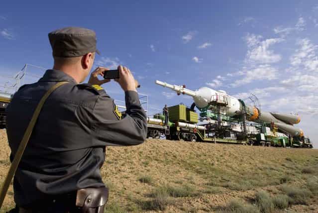 A policeman takes a picture of the Soyuz TMA-04M spacecraft during transportation to its launch pad at the Baikonur cosmodrome May 13, 2012