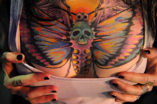 A woman shows off her tattoo during during an International Congress of Tattoo Artists in Moscow, on May 18, 2012