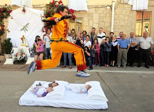 A man representing the devil leaps over babies during the festival of El Colacho in Castrillo de Murcia near Burgos, Spain