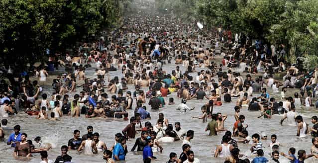 People swim in a canal to cool off as temperatures reach 111.2 degrees Fahrenheit (44 °C) in Lahore, Pakistan on June 17, 2012