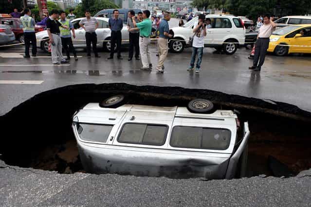 A van is trapped in a hole after a cave-in happened on Fuxing road in Guilin, China, due to long-term rainfall, June 8, 2012 A van is trapped in a hole after a cave-in happened on Fuxing road in Guilin, China, due to long-term rainfall, June 8, 2012