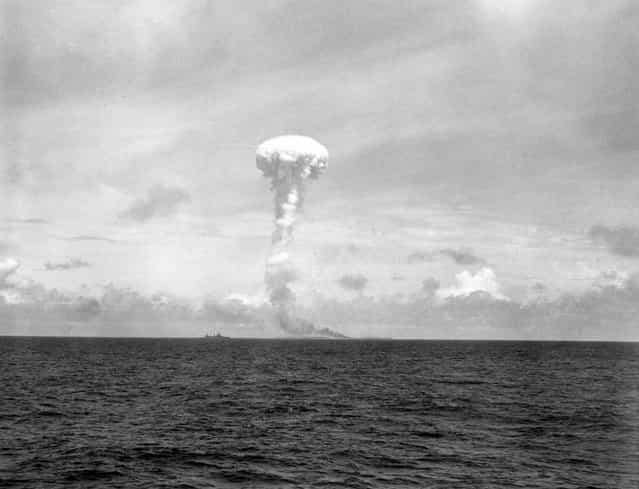 Navy shells hit jackpot, raise extremely high plume of smoke (note tiny ship on the left)