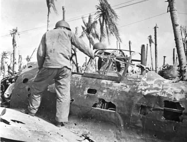 American marine surveys Jap plane wrecked on ground