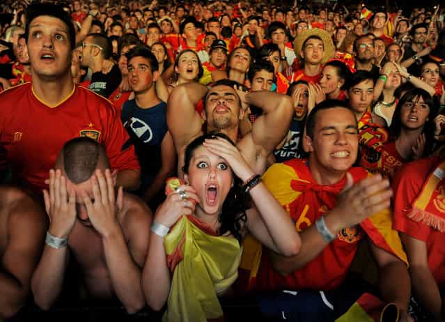 Spanish fans react while watching on a giant outdoor screen on Paseo de La Castellana street the UEFA EURO 2012 semi-final match between Spain and Portugal on June 27, 2012 in Madrid, Spain