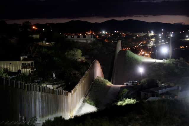 The border wall is illuminated at night July 6, 2012 in Nogales, Arizona