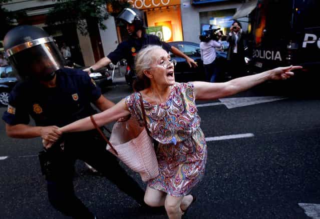 A demonstrator is detained by the police office during a protest against austerity measures announced by the Spanish government, in front of the Popular Party in Madrid on July 13, 2012