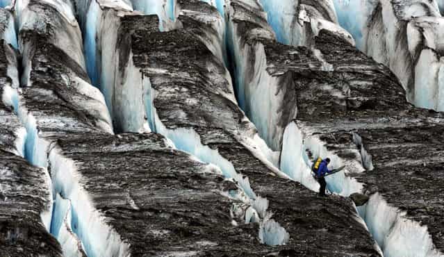 A Joint Task Force-Alaska Team member negotiates the crevasses on Colony Glacier as debris from a suspected 1952 crash of a U.S. Air Force C-124 Globemaster with 52 people is recovered on July 12, 2012