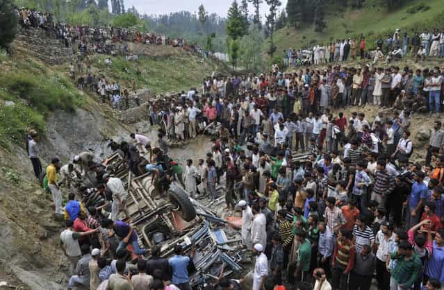 Kashmiri villagers stand near the wreckage of a bus at Nambal Nard some 55 kms northwest of Srinagar on July 11, 2012