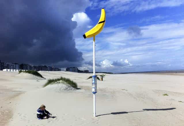 Three year-old boy Alessandro plays near a banana-shaped meeting point for lost children on the beach of Oostduinkerke July 11, 2012