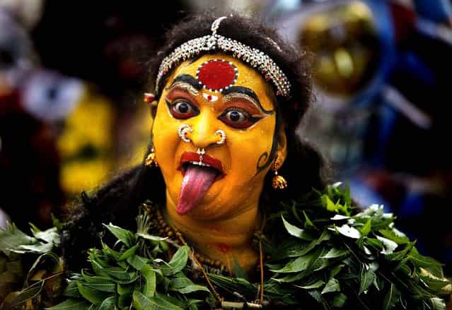 A Hindu woman dressed as the goddess Mahakali performs during a [Bonalu] festival in Hyderabad, India on July 16, 2012. Bonalu is a Hindu folk festival of the Telangana region in the Indian state of Andhra Pradesh. (Photo by Mahesh Kumar A/Associated Press)