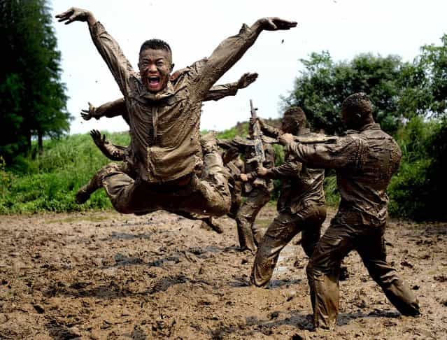 Paramilitary policemen train in the mud in Chuzhou city in central China's Anhui province on July 18, 2012. (Photo by Associated Press)