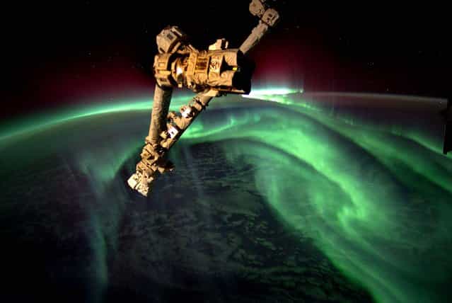 This image released by NASA, taken by astronaut Joe Acaba onboard the International Space Station at an altitude of approximately 240 miles, shows the Aurora Australis, also known as the Southern Lights, on July 15, 2012. The Canadarm2 robot arm is in the foreground. (Photo by Joe Acaba/NASA)