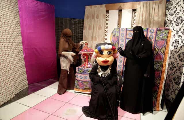 Heba Seraj, Shaimaa Hamid and Shaimaa Abdelhamid prepare to film a segment of a Ramadan program at the Maria Channel's studio in Cairo on July 22, 2012. The first Egyptian satellite channel operated by women wearing the niqab, or face veil, launched on the first day of the holy month of Ramadan. The station manager says he hopes the full face-veiled women will set an example for others by showing a [new kind of woman] as a role model. (Photo by Maya Alleruzzo/Associated Press)
