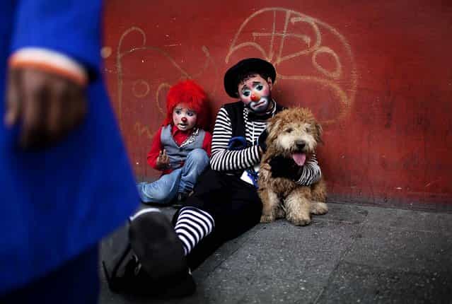 Two clowns take a rest on a sidewalk during the fourth annual Latin American Clown Congress in Guatemala City on July 24, 2012. Clowns from Central America and South America and the Caribbean have gathered for three days to exchange ideas and attend workshops. (Photo by Rodrigo Abd/Associated Press)