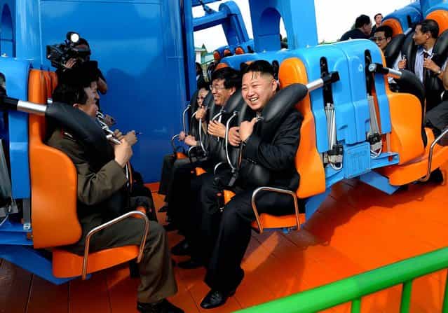 In this undated photo released by the Korean Central News Agency, North Korean leader Kim Jong Un, center, reacts on a ride as he attends the completion ceremony of the Rungna People's Pleasure Ground in Pyongyang on July 26, 2012. (Photo by Korean Central News Agency via Korea News Service)
