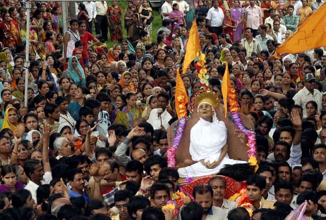 Members of the Jain community march outside the Digambar Jain temple with the body of Ajaymati Mataji, who is believed to have died after performing Sallekhena, or the holy rite of fasting to death in Bhopal, India, on July 26, 2012. Supporters of this salvation ritual believe that Sallekhena cannot be considered suicide, but rather something one does with full knowledge and intent. (Photo by Associated Press)