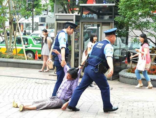 Police drag a drunk man to the koban in Shibuya, Japan on July 21, 2012. (Photo by Mark Buckton)