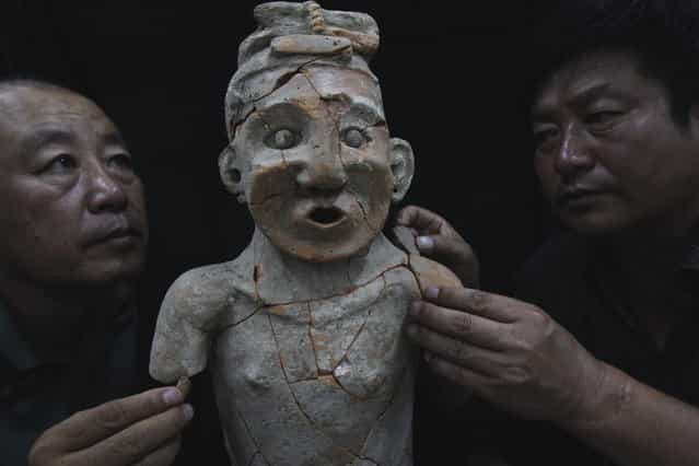 Archaeologists repair a pottery statue found in Aohan Banner, North Chinas Inner Mongolia autonomous region, July 3, 2012. (Photo by Xinhua)