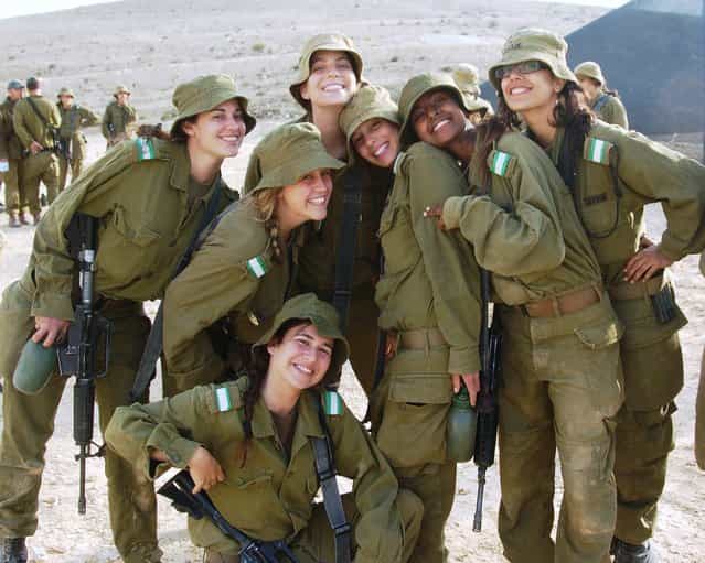 [Female Soldiers Take a Break in the Desert Sun], May 16, 2011. A diverse group of female infantry instructors take a break from their intensive course in southern Israel. After completing the infantry instructors course, the female instructors are responsible for training combat soldiers on battlefield tactics including various weaponry and combat armored vehicles.
