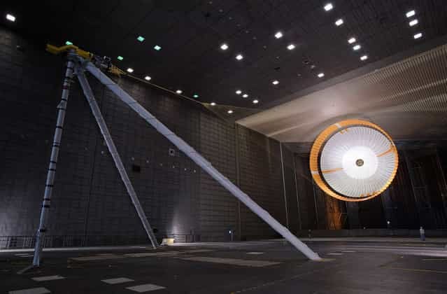 The parachute for NASAs Mars Science Laboratory passed flight-qualification testing in March and April 2009 inside the worlds largest wind tunnel, at NASA Ames Research Center, Moffett Field, California. In this image, an engineer is dwarfed by the parachute, the largest ever built to fly on an extraterrestrial flight. It is designed to survive deployment at Mach 2.2 in the Martian atmosphere, where it will generate up to 65,000 pounds of drag force. The parachute has 80 suspension lines, measures more than 50 meters (165 feet) in length, and opens to a diameter of nearly 16 meters (51 feet). (Photo by NASA/Ames Research Center/JPL)