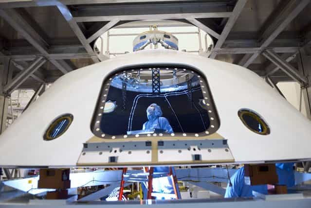 In the Payload Hazardous Servicing Facility at NASAs Kennedy Space Center in Florida, technicians process the backshell for the Mars Science Laboratory. The spacecrafts backshell carries the parachute and several components used during later stages of entry, descent and landing of MSLs rover, Curiosity. (Photo by NASA/Jim Grossmann)