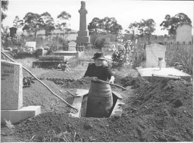 Josephine Smith digging a grave at the Drouin Cemetery, Victoria, ca. 1944. Meet Mrs. Josephine Smith, aged 84, whose hobby is digging graves. She lives in Drouin, a typical little farming town (1100 people), in southern Australia, 60 miles out of the Victorian capital, Melbourne