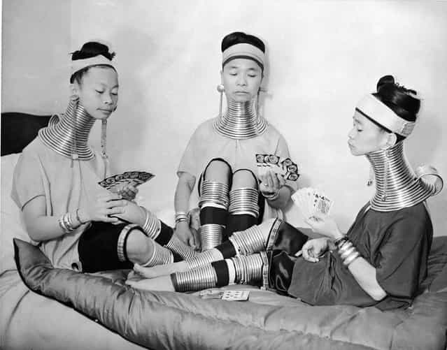 Three Burmese women members of a circus play cards as they wear the brass neck and leg rings traditionally worn by Padaung women since childhood and which cannot be removed, London, January 4, 1935. (Photo by Keystone)
