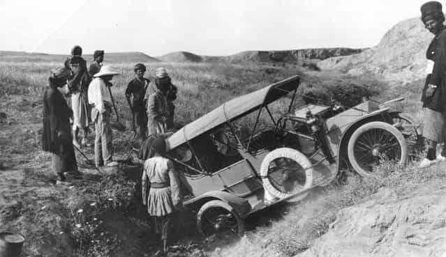 A car ends up in a ditch after being driven off the road, somewhere in Persia, circa 1925.