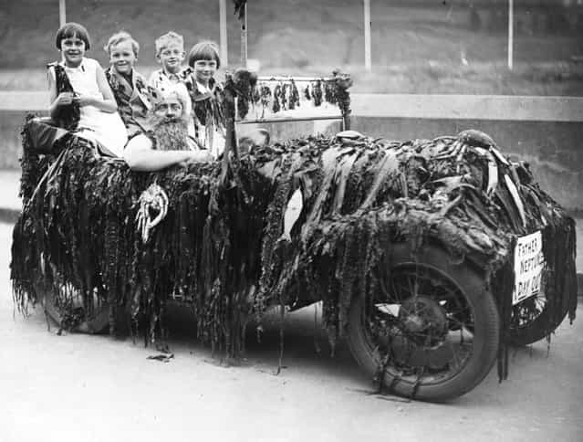 Children sitting in the back of an Austin Seven car driven by a man dressed as King Neptune, in the procession to celebrate the opening of Dartmouth's Carnival Week. 13th July 1936.