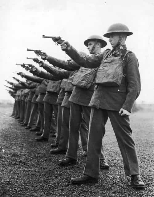 A line of soldiers firing handguns during a training session, circa 1920. (Photo by Keystone)