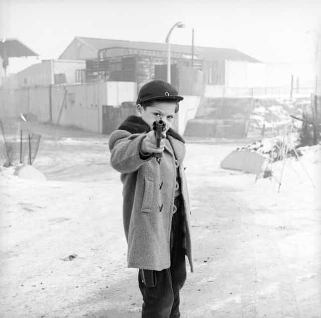 A young boy looks down the sights of a revolver, January 1958. (Photo by R. Mathews/BIPs)