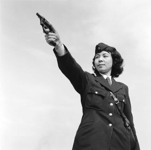 Tokyo policewoman Haruko Tanaka of the Asakusa ward aims her gun during shooting practice, circa 1955. (Photo by Evans/Three Lions)