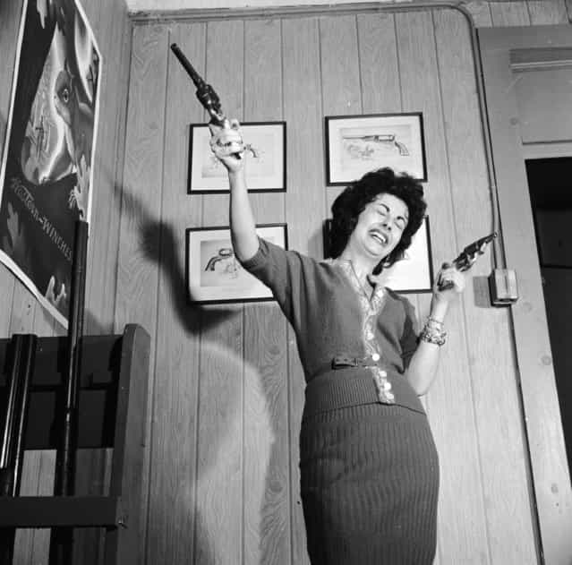 Lola Medina demonstrates the effects of handling a pair of pistols at Centre Firearms, a manufacturer of fake weapons for use in showbusiness, circa 1955. (Photo by Vecchio/Three Lions)