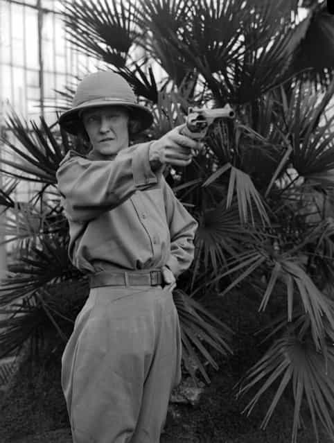 Dressed for deepest Africa and wearing a solar topee, Mrs. T. G. Glover takes aim with her revolver in the Botanic Gardens at Kew, London. 2nd February 1931. (Photo by Fox Photos)