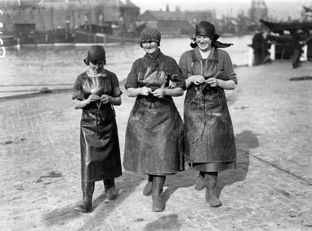 Three Scottish herring girls knitting whilst waiting for the arrival of the fishing fleet at Great Yarmouth in England, 1929. Thousands of women travel from Scotland to Great Yarmouth to process the catch during the autumn herring season. (Photo by Topical Press Agency)