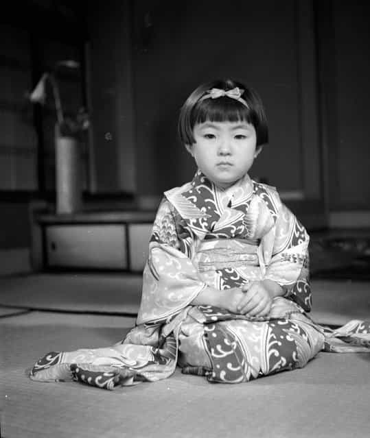 A child wearing a typical Japanase Geisha kimono sits in a Geisha pose, circa 1950. (Photo by Evans/Three Lions)