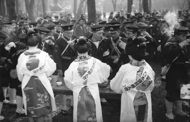 Geisha girls, wearing aprons over their kimonos, serving Japanese sailors on Tokyo Navy Day, circa 1937. (Photo by Hulton Archive)